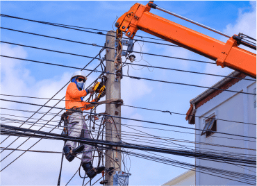Electrical worker in protective gear working on an electrical line
