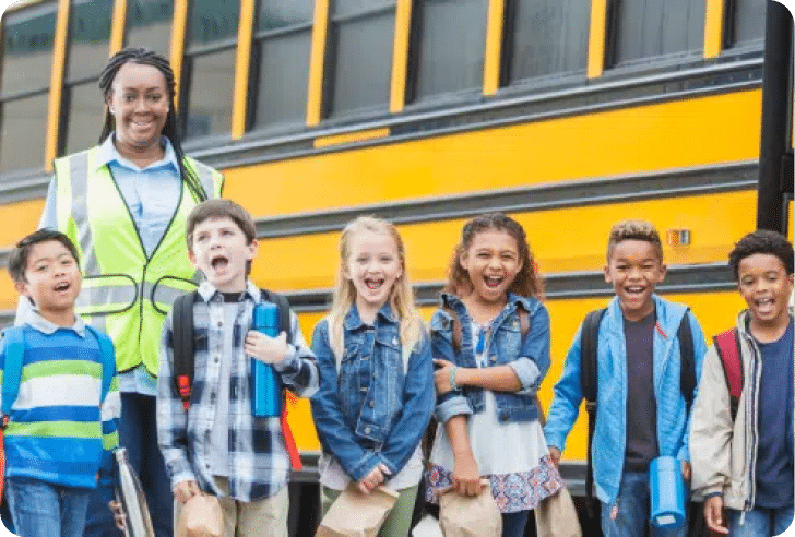 School Bus Driver ushering in a group of students to a school bus