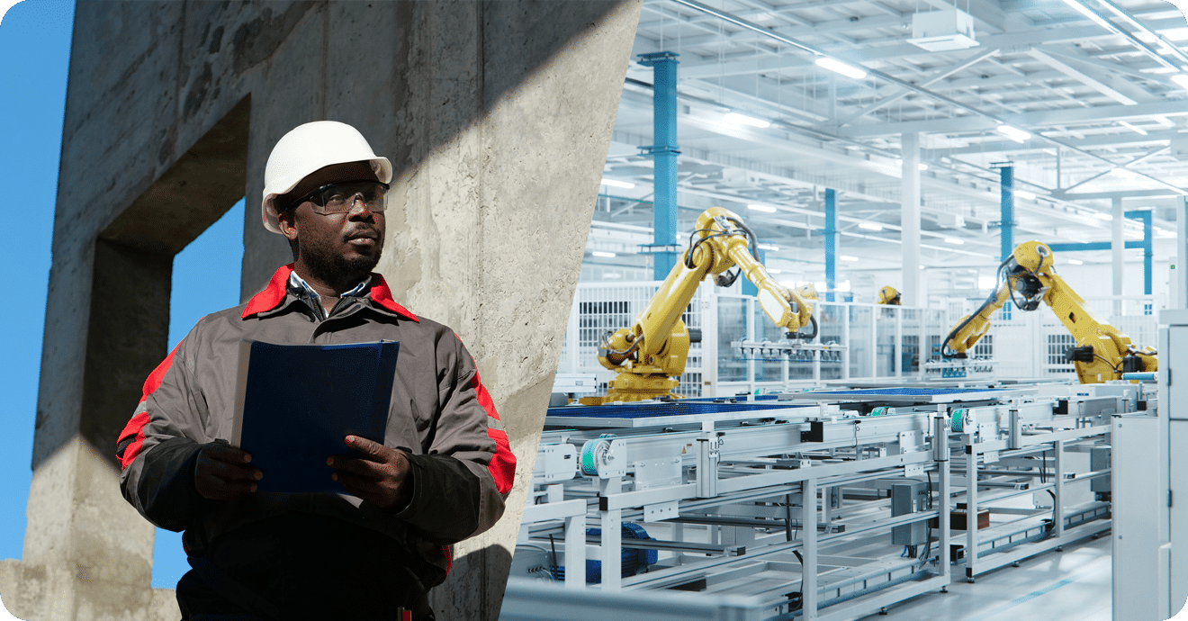 An employee in a hard hat surveys an industrial manufacturing facility