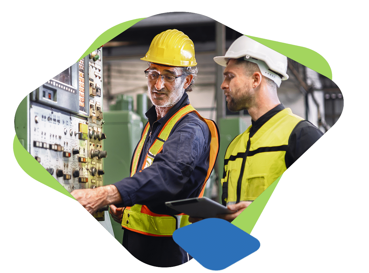 Two employees review a machines electrical controls for safety training purposes